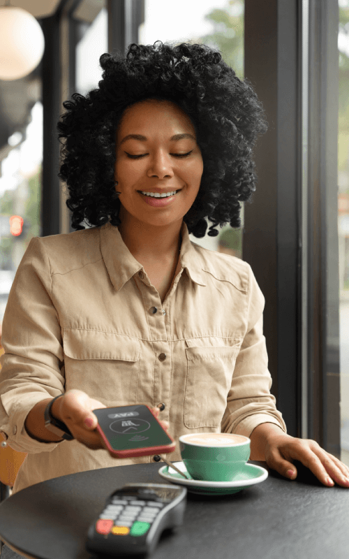 woman paying with phone at cafe