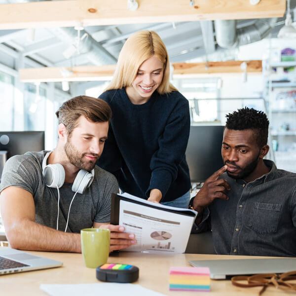 three diverse colleagues reviewing reports