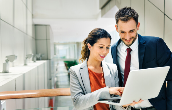 two colleagues review data on a laptop
