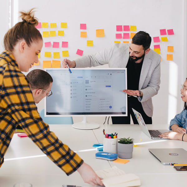 team discusses ideas on a monitor
