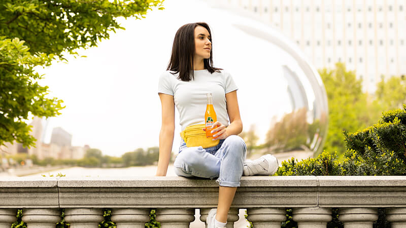 woman sits with drink in park